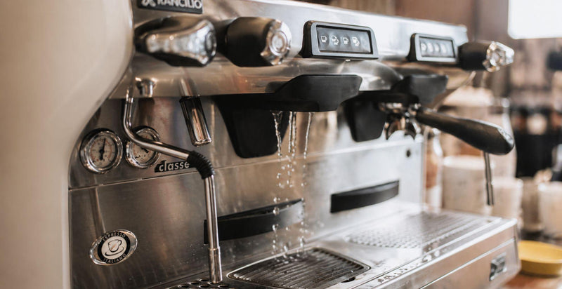 Rancilio Classe 5 espressokone ammattikäytössä, höyryputki ja gruppot toiminnassa kahvilaympäristössä