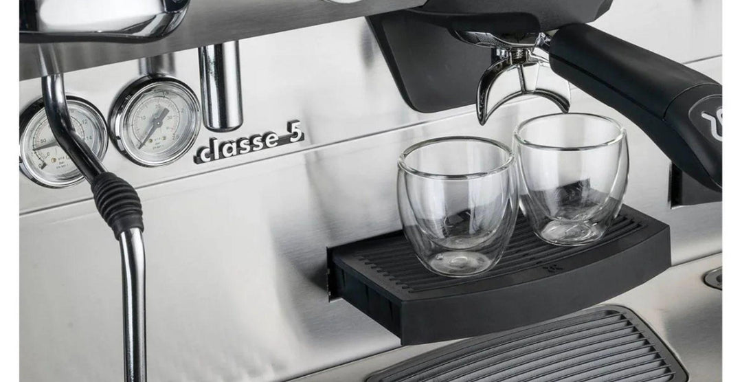 Rancilio Classe 5 espressokone lähikuvassa, tuplalasikupit espressolle ja höyryputki ammattikäytössä